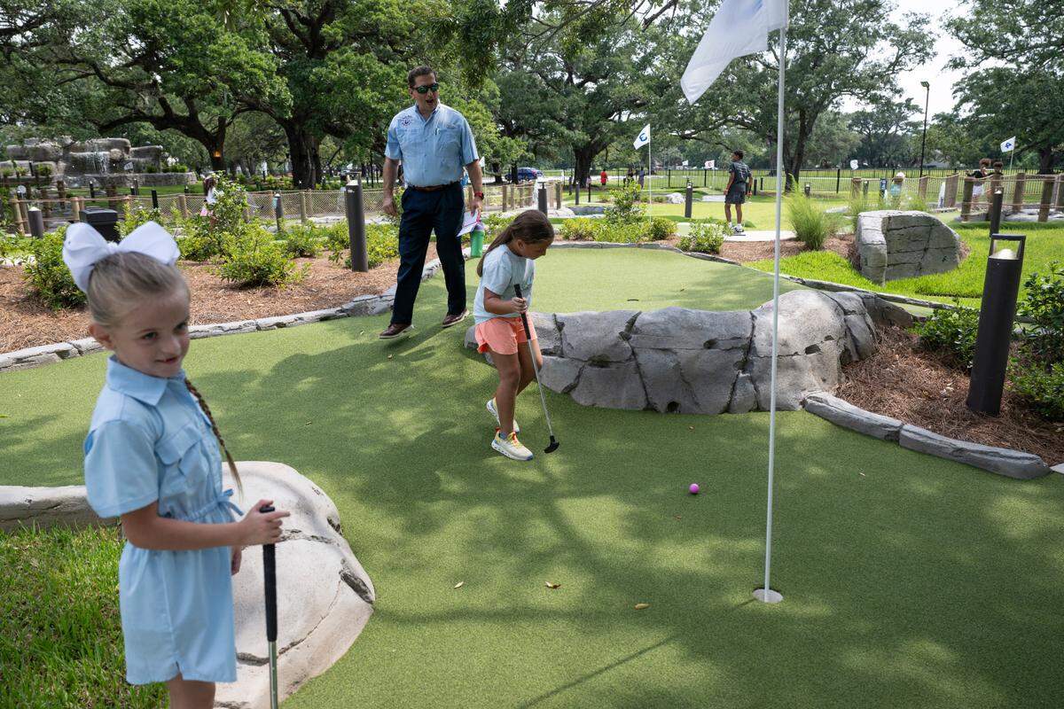 Gulfport city council member R. Lee Flowers plays mini golf with his kids at Hippie Fish at Centennial Plaza in Gulfport on Thursday, June 26, 2025.