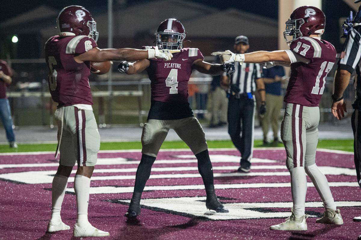 Picayune’s Darrell Smith, Chris Davis and Elysha Diodati mimic a popular Spiderman meme after scoring a touchdown during a playoff game at Lee-Triplett Stadium in Picayune on Friday, Nov. 17, 2023.