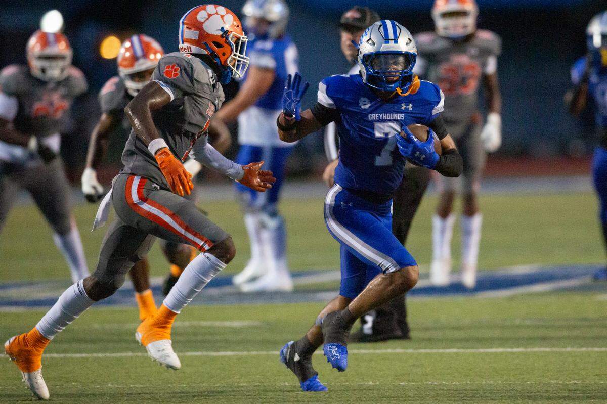 Ocean Springs’ Bryhsen Smith holds off a defender during a game against Madison Central at Greyhound Stadium in Ocean Springs on Friday, Aug. 30, 2024.