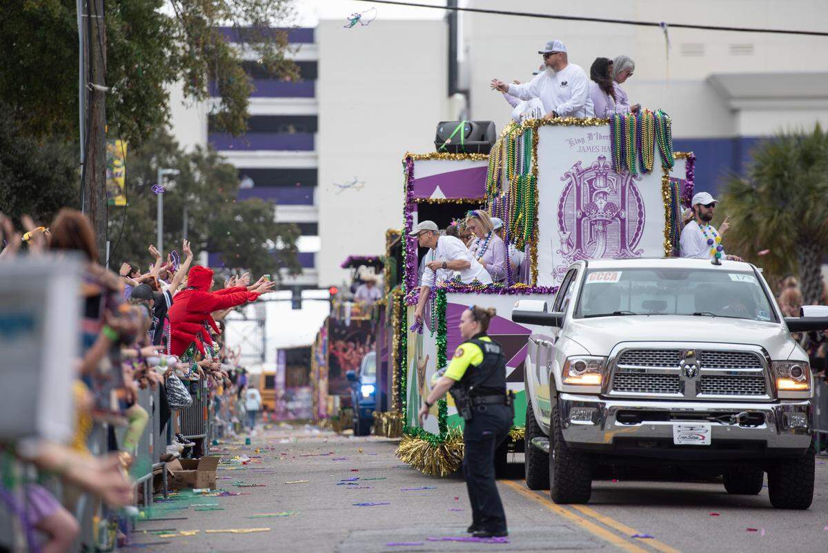 Float riders throw beads to the crowd during the Gulf Coast Carnival Association Mardi Gras parade in Biloxi on Tuesday, March 4, 2025.