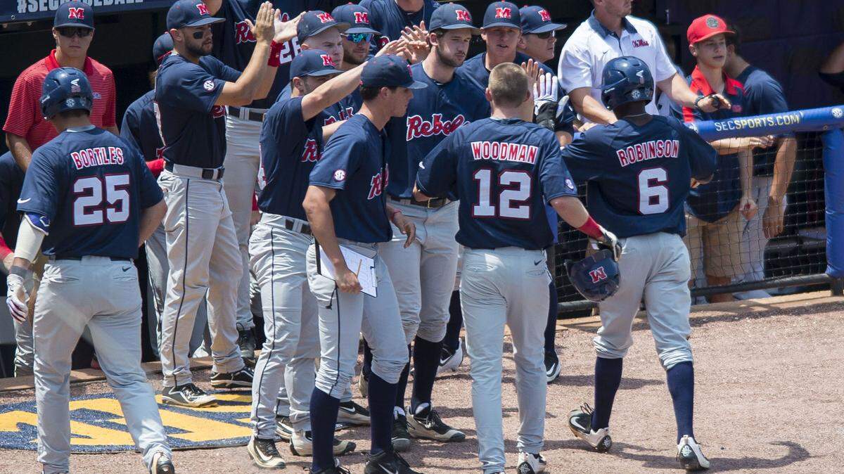VASHA HUNT/ASSOCIATED PRESS 
 Ole Miss players greets outfielder J.B. Woodman (12) and infielder Errol Robinson (6) who both scored on a double by Henri Lartigue during a college baseball game against South Carolina in the Southeastern Conference tournament in Hoover, Ala., Wednesday.