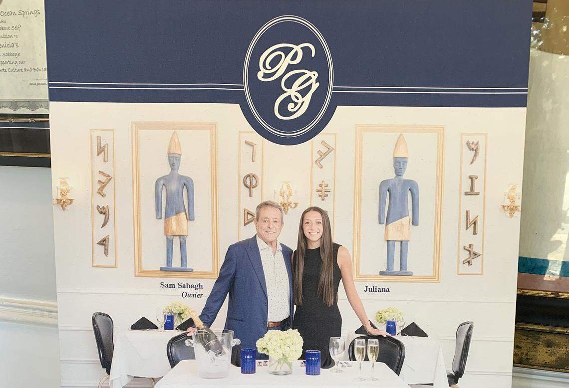 A sign featuring owner Issam Sabagh and his daughter Juliana Sabagh welcomes customers to Phoenicia Gourmet Cuisine in Ocean Springs. The restaurant is closing to move to a new location.