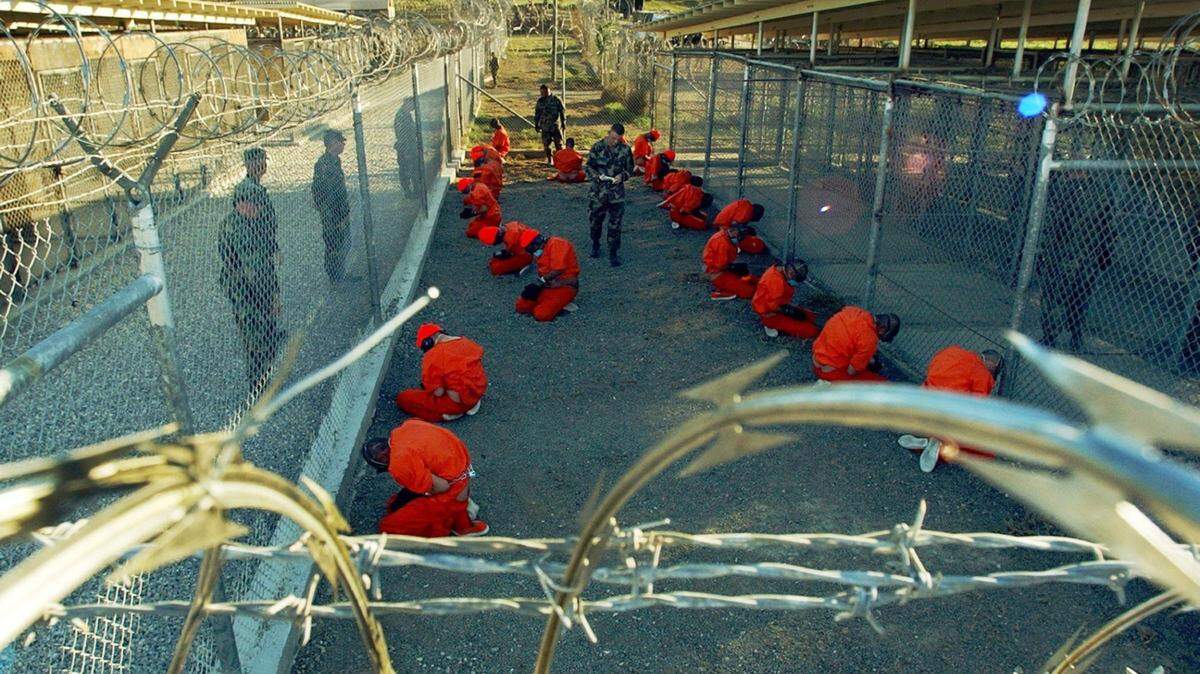 The now-iconic images of the first detainees to land at Guantanamo Bay, Cuba - capturing a moment of men on their knees in orange jumpsuits behind barbed wire fences. The Pentagon has built more solid prison space since then. (Shane T. McCoy - U.S. Navy Petty Officer)