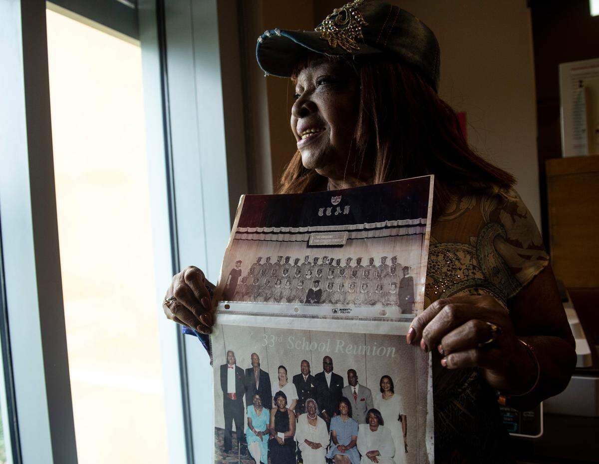 Ruthie Taggart-White poses for a portrait with a photo of her high school class at 33rd Ave School, the class of 1956, and their 40 year reunion photo at East Biloxi Library on Saturday, July 31, 2021.