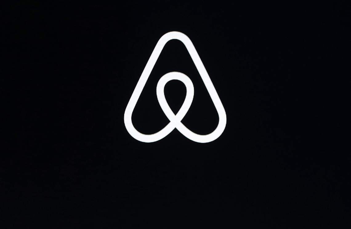 FILE - This Feb. 22, 2018, file photo shows an Airbnb logo during an event in San Francisco. Home-sharing site Airbnb posted a $3.9 billion loss in the fourth quarter of 2020 as it suffered from the pandemic downturn in travel and recorded one-time costs for becoming a public company. (AP Photo/Eric Risberg, File)