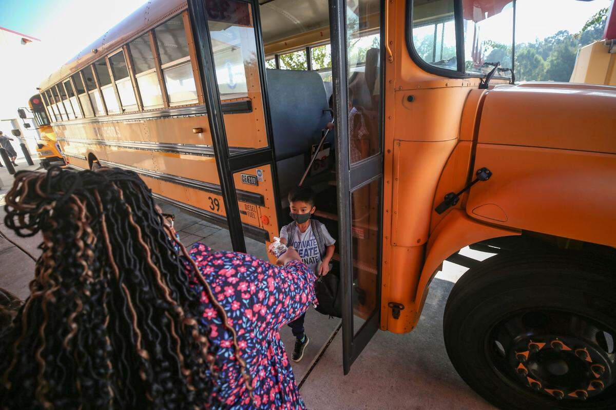 Students load off of school buses at North Bay Elementry School on the first day of classes August 5, 2020 in Biloxi.