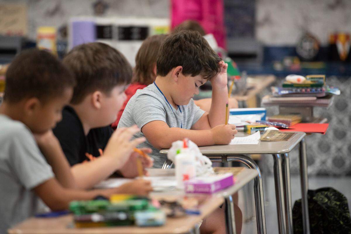 Elementary school students color in coloring sheets on the first day of school at Magnolia Park Elementary on Friday, Aug. 5, 2022.