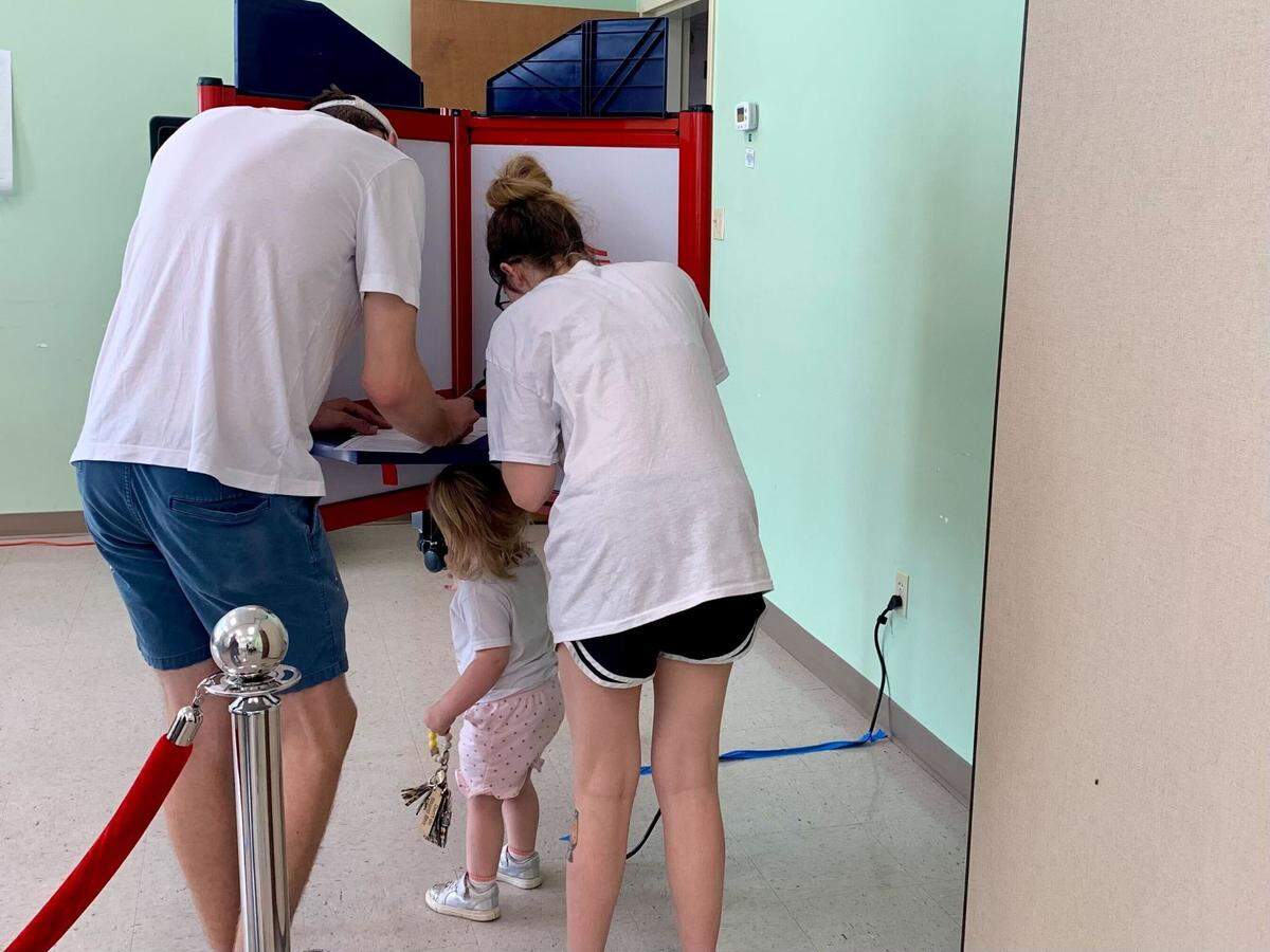A child plays under the voting table Tuesday, Nov. 5, 2024, at the First Presbyterian Church in Pascagoula.