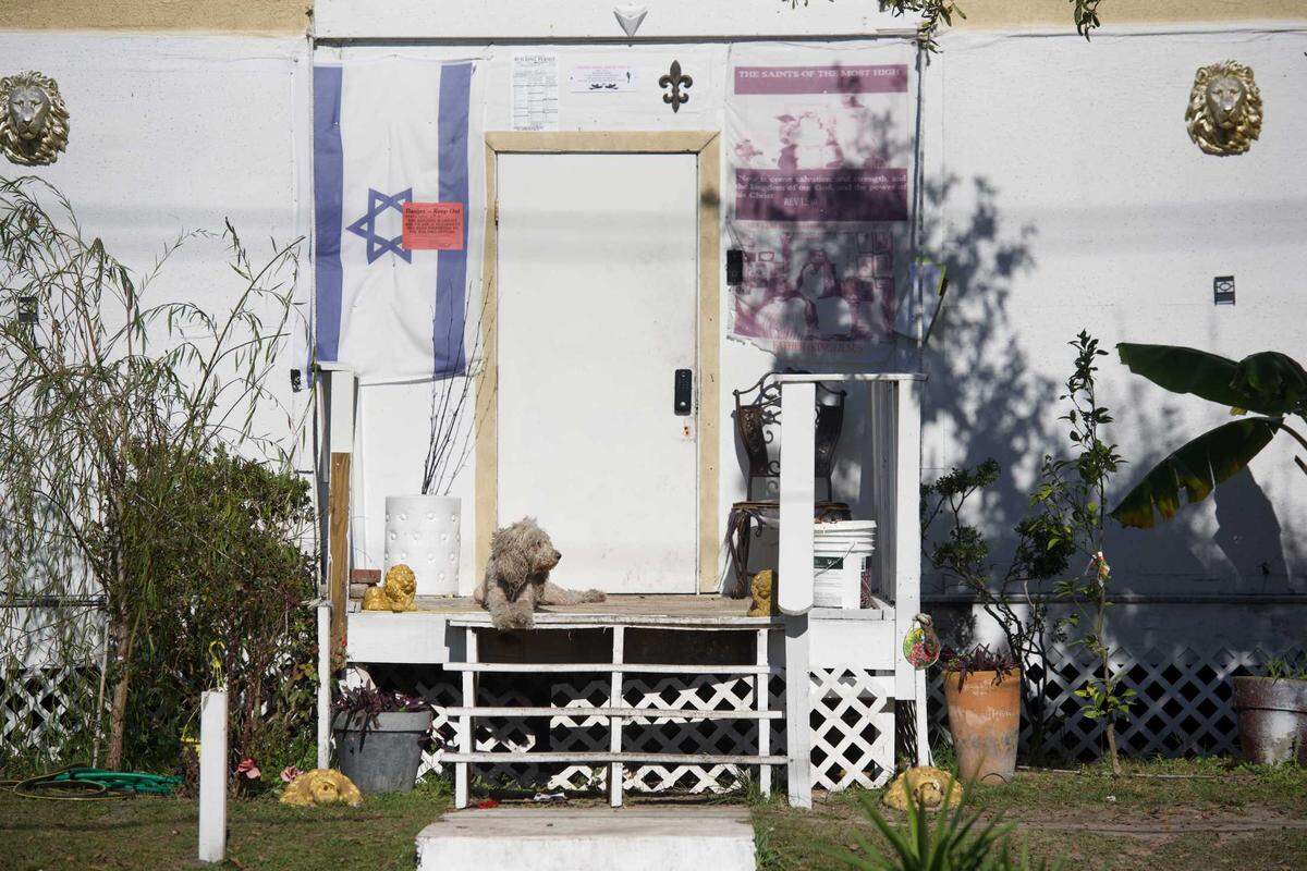 A dog lingers on the porch of the home of Father Jesus, which was condemned and cleared by Gulfport on Dec. 22, 2021.