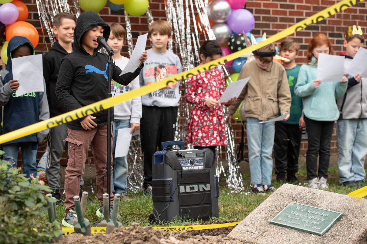 Students at W. J. Quarles Elementary in Long Beach, give a speech before helping to dig up a time capsule on Friday, Dec. 13, 2024, that was buried in 1999.