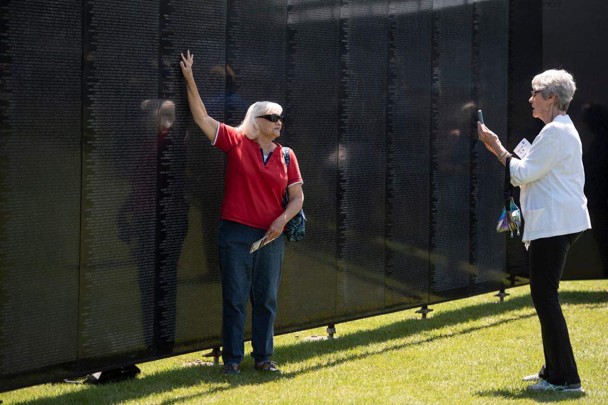 Visitors take photos with The Wall That Heals, a traveling three-quarter scale replica of the Vietnam Veterans Memorial in D.C., while it is on display at the D’Iberville Sports Complex in D’Iberville on Thursday, April 10, 2025.