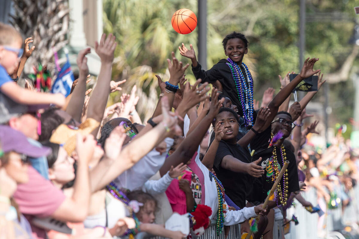 Parade watchers cheer for throws during the Ocean Springs Elks Club Mardi Gras Parade in Ocean Springs on Saturday, Feb. 15, 2025.
