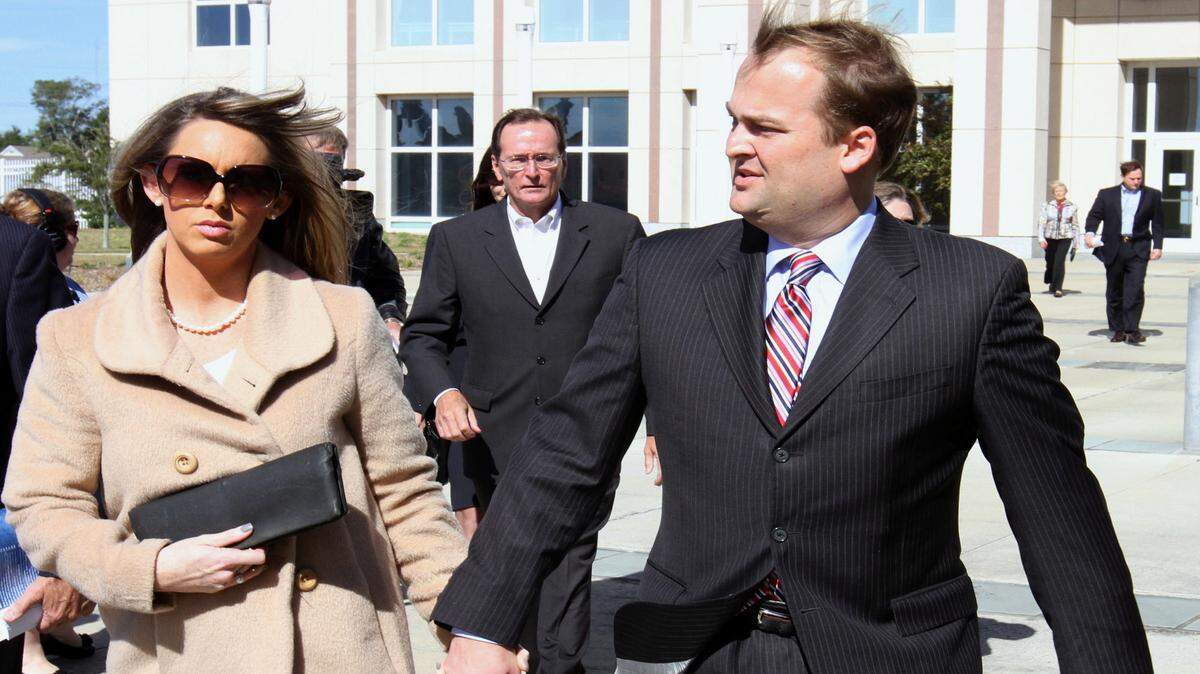 JOHN FITZHUGH/SUN HERALD/2013 
 Scott Walker, right, his wife, Trinity and father, Bill, center, leave the federal courthouse in Gulfport after Scott and Bill's initial appearance on Nov. 8, 2013. Walker was released from prison Tuesday after serving one year, one month and 18 days.