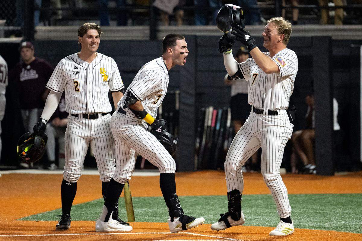 Southern Miss infielder Seth Smith (3) celebrates scoring with outfielder Caleb Stelly (2) and outfielder Ben Higdon (7) during a baseball game at Pete Taylor Park in Hattiesburg on Tuesday, March 3, 2026.