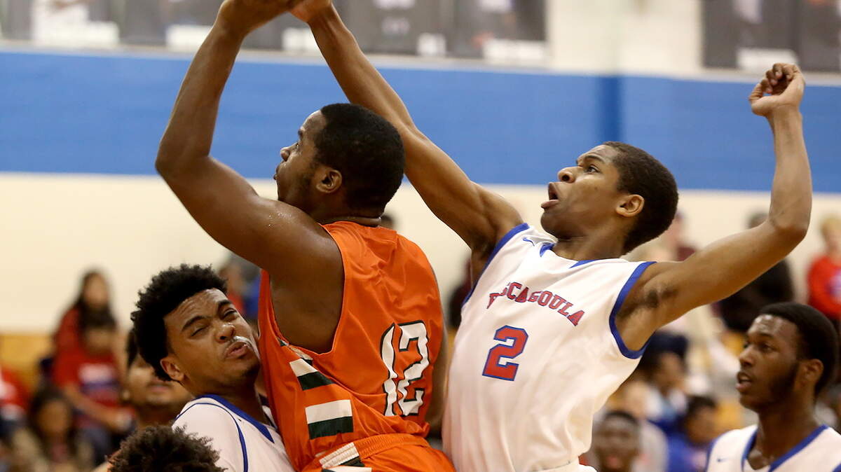 AMANDA McCOY/SUN HERALD 
 Pascagoula's Jacques Belford, left, and Paris Weathersby, right, put pressure on West Harrison's D'Anthony Bowie as he attempts a shot on Tuesday, January 12, 2016, at Pascagoula High. Pascagoula defeated West Harrison, 50-48.