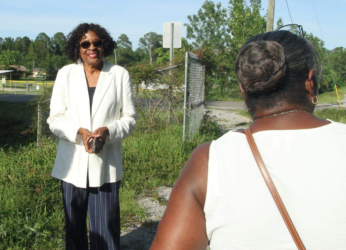 Gulfport Councilwoman Ella Holmes-Hines speaks with constituents while standing on the Forest Heights levee that protects the subdivision from flooding. Forest Heights is one of several subdivisions where residents fear a new road the city proposes will exacerbate flooding. Holmes-Hines was the only council member to oppose taking conservation property to build the road..