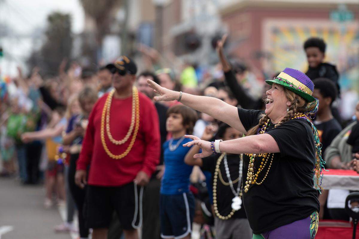 Paradegoers catch beads during the Krewe of Gemini parade in downtown Gulfport on Saturday, Feb. 10, 2024.