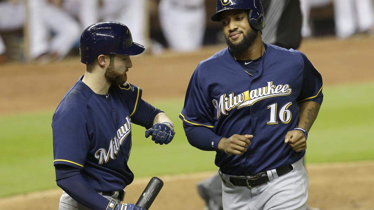 ALAN DIAZ/ASSOCIATED PRESS 
 Milwaukee Brewers' Domingo Santana (16) is congratulated by teammate Jonathan Lucroy (20) after Santana scored on a base hit by Ryan Braun in the ninth inning of a baseball game, Tuesday, May 10, 2016, in Miami.