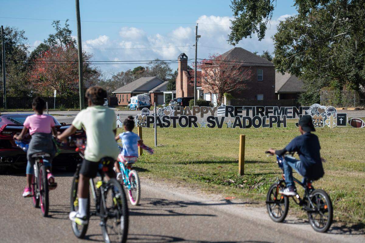 Children of Handsboro Baptist Church bike past the church in a parade for the retirement of the church’s pastor, Seymour Venson Adolph, Jr., in Gulfport on Saturday, Dec. 4, 2021.