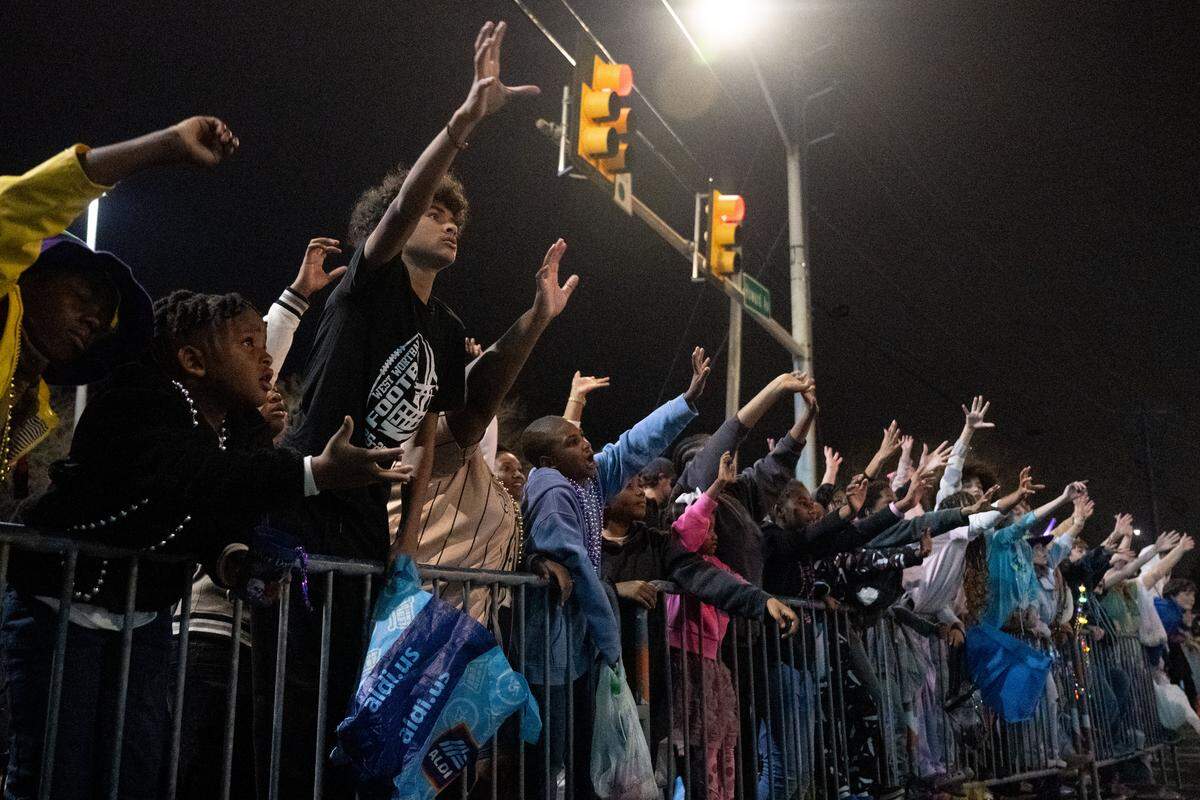 Hundreds of parade attendees reach out for throws as floats pass by during the Krewe of Neptune parade in Biloxi on Saturday, Feb. 14, 2026.