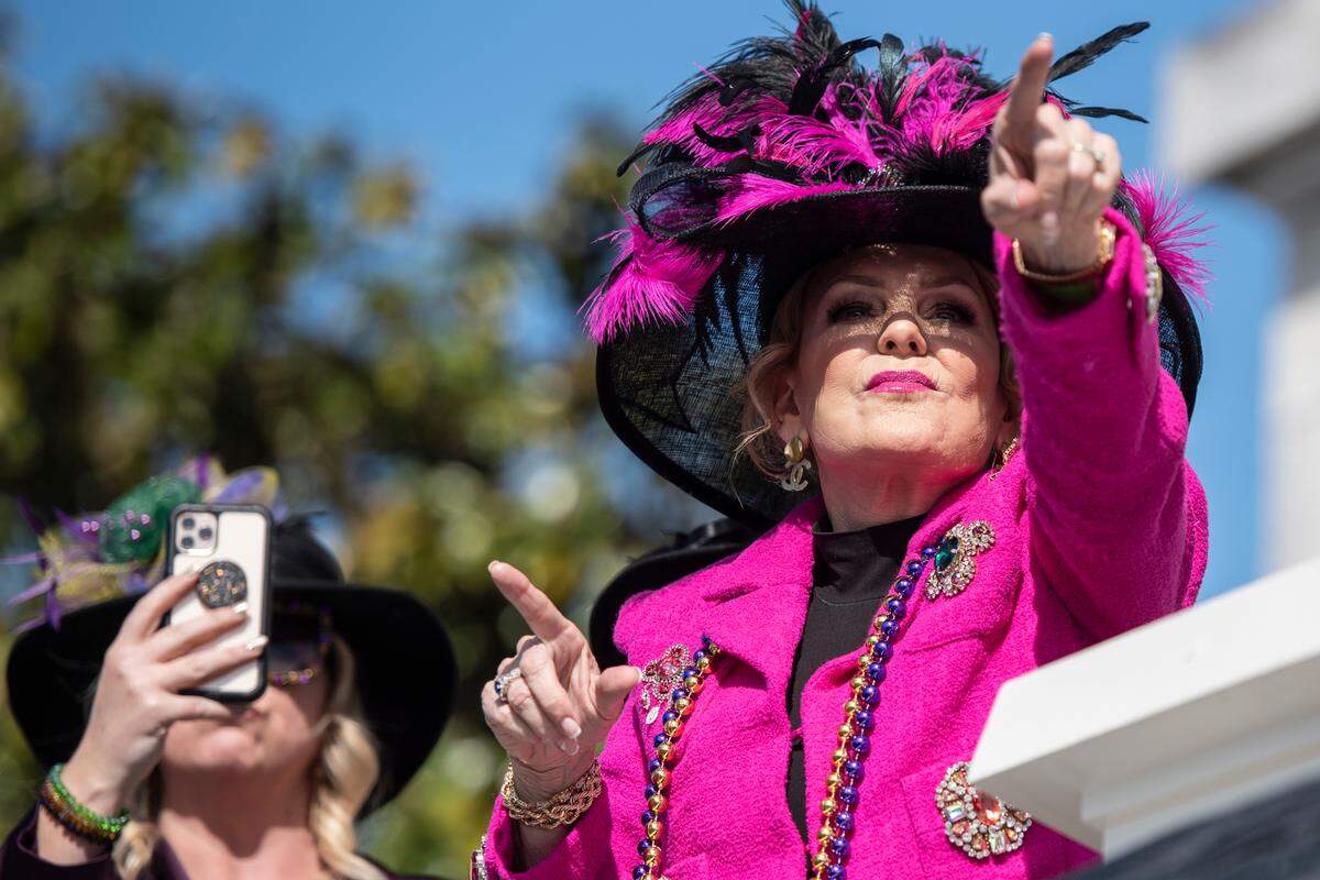 Paradegoers point to floats during the Gulf Coast Carnival Association’s Mardi Gras parade in Biloxi on Tuesday, Feb. 13, 2024.