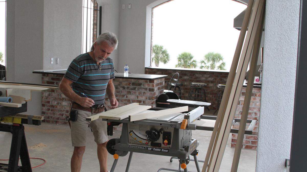 ANITA LEE/SUN HERALDTrim carpenter Monte Lott of Tower Builders is putting some of the finishing touches on the Beach Boulevard home of Dan and Randy Smith in Gulfport. Plum Homes is contractor on the custom project.