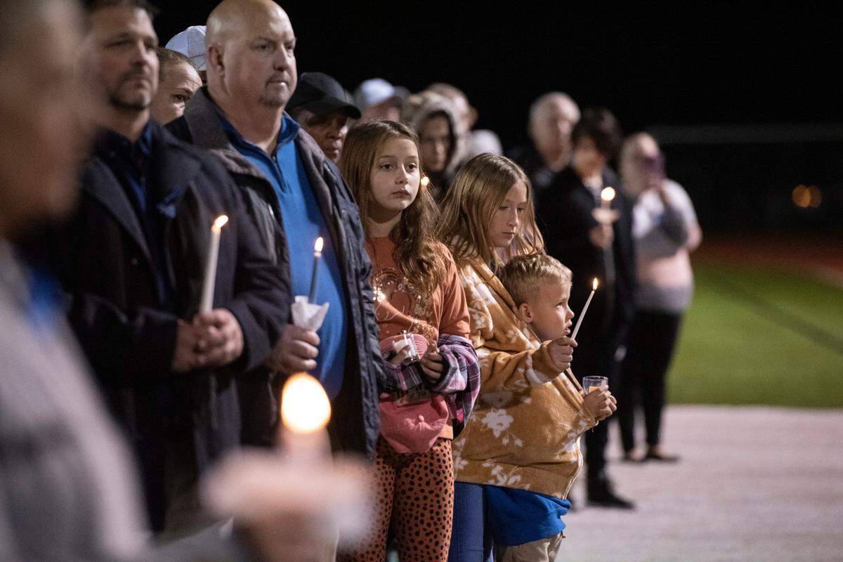 Community members listen during a candlelit vigil for Bay St. Louis Sgt. Steven Robin and officer Branden Estorffe at Tiger Stadium in Bay St. Louis on Thursday, Dec. 15, 2022. Robin and Estorffe were killed on Wednesday when a woman shot both of them.
