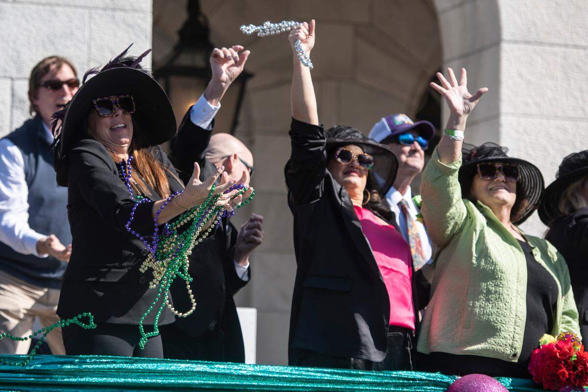 Paradegoers catch beads during the Gulf Coast Carnival Association’s Mardi Gras parade in Biloxi on Tuesday, Feb. 13, 2024.