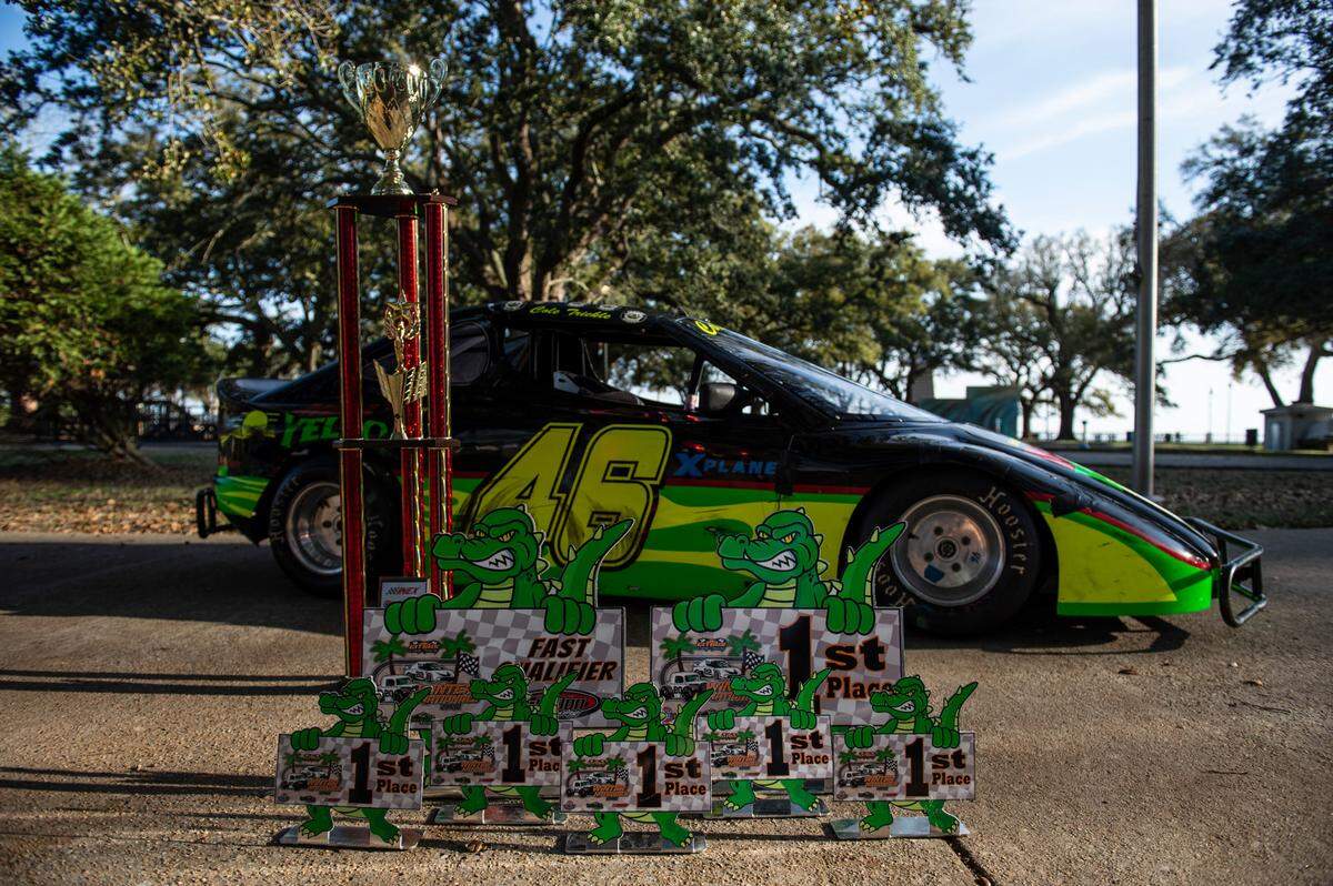 Various trophies won by Cole Denton, aka “Cole Trickle”, next to his Bandolero racecar decorated to reflect the car the Days of Thunder character drove in the movie at Pascagoula Beach Park in Pascagoula on Thursday, March 10, 2022.
