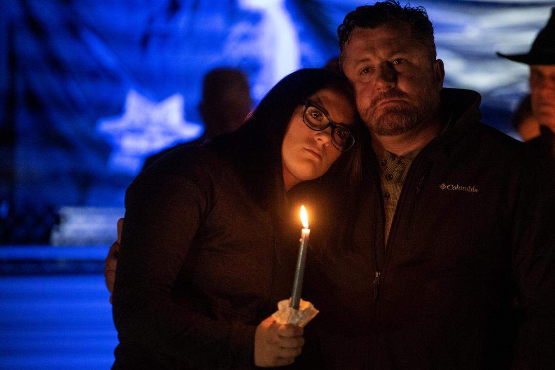 Lilly and Ian Estorffe, the sister and father of officer Branden Estorffe, embrace during a candlelit vigil for Bay St. Louis Sgt. Steven Robin and officer Branden Estorffe at Tiger Stadium in Bay St. Louis on Thursday, Dec. 15, 2022. Robin and Estorffe were killed on Wednesday when a woman shot both of them.