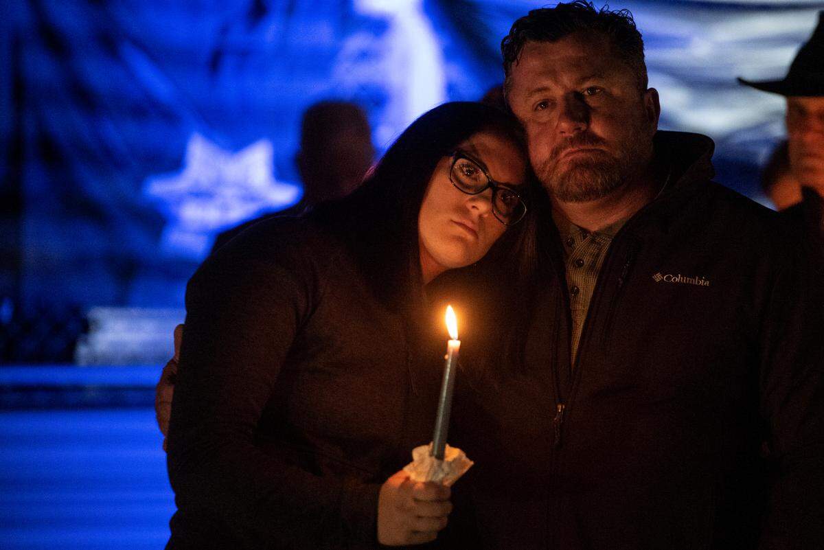 Family members of officer Branden Estorffe embrace during a candlelit vigil for Bay St. Louis Sgt. Steven Robin and officer Branden Estorffe at Tiger Stadium in Bay St. Louis on Thursday, Dec. 15, 2022. Robin and Estorffe were killed on Wednesday when a woman shot both of them.