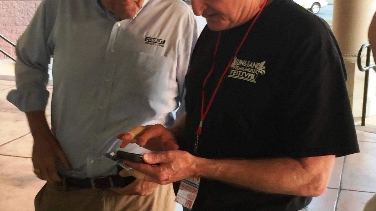 JEFF CLARK/SPECIAL TO THE SUN HERALDCoastian Mark Cumbest buys a ticket to the Sun & Sand Film festival from one of its organizers, Bobby Benton.