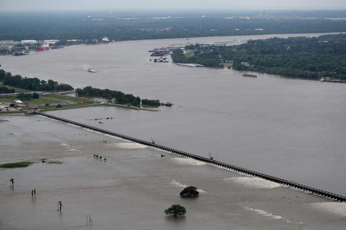 Workers open bays of the Bonnet Carre Spillway, to divert rising water from the Mississippi River to Lake Pontchartrain, upriver from New Orleans, in Norco, La., Friday, May 10, 2019. Torrential rains in Louisiana brought such a rapid rise on the river that the Army Corps of Engineers is opening the major spillway four days earlier than planned. Spokesman Ricky Boyett says the river rose six inches in 24 hours, with more rain expected through the weekend. (AP Photo/Gerald Herbert)