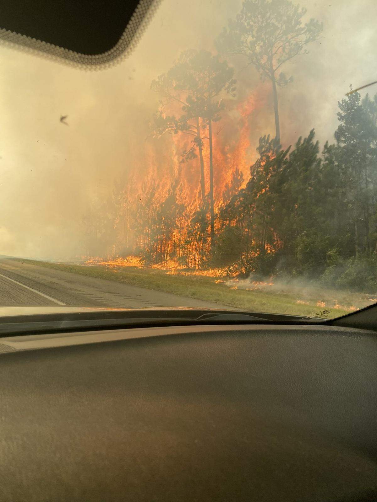 A large grass fire burns at the 2 mile-marker on I-10 in Hancock County on Friday, Aug. 10, 2023. The Interstate has been shut down for safety reasons.