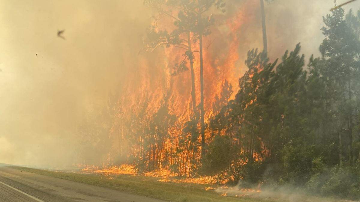 A large grass fire burns at the 2 mile-marker on I-10 in Hancock County on Friday, Aug. 10, 2023. The Interstate has been shut down for safety reasons.