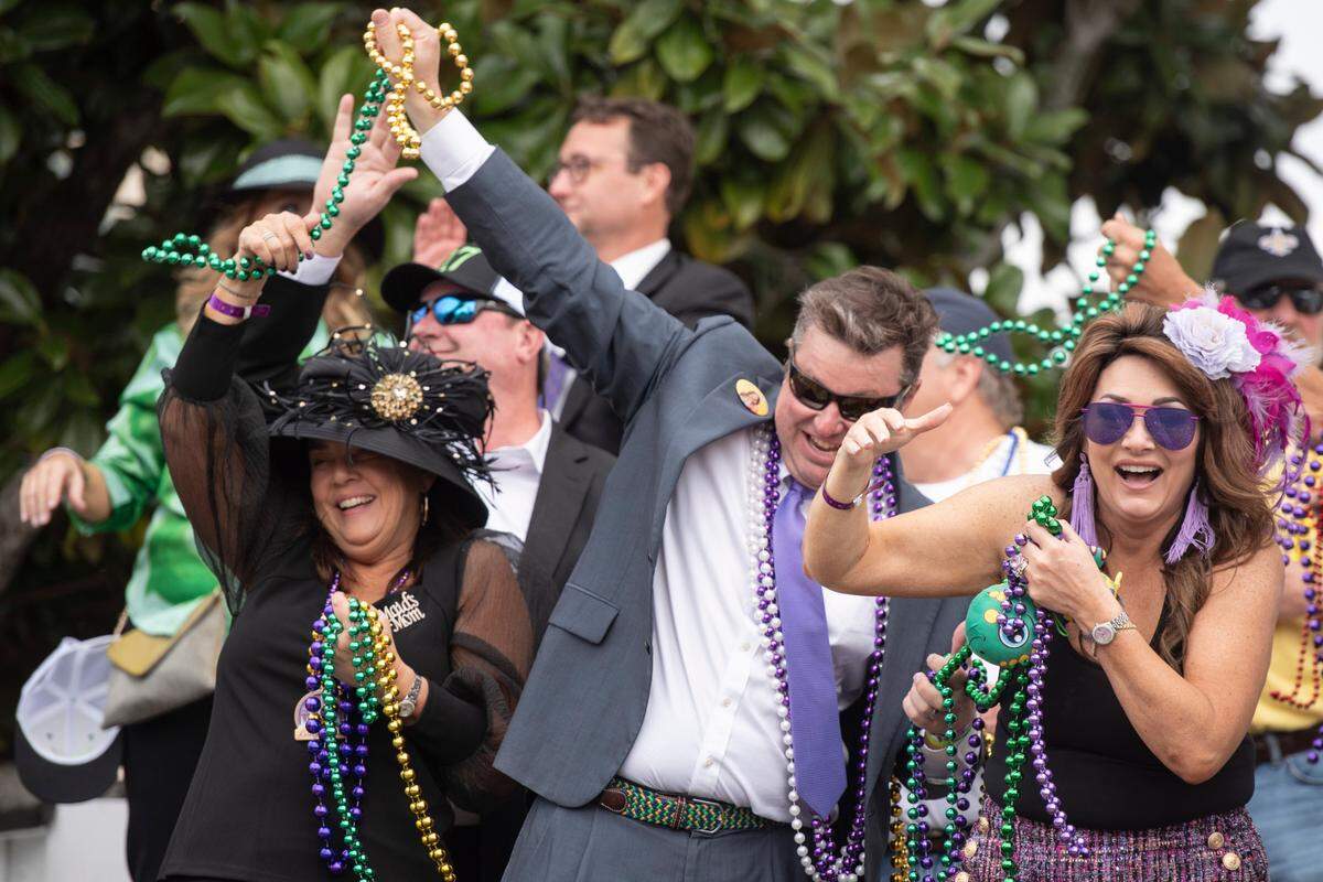 Parade watchers catch beads and other throws during the Gulf Coast Carnival Association Mardi Gras parade in Biloxi on Tuesday, March 4, 2025.