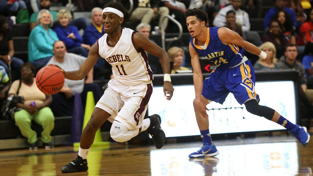 AMANDA McCOY/SUN HERALD 
 George County's Laraymond Spivey dribbles past St. Martin's Stacee St. Julian on Friday, Feb. 19, 2016, at D'Iberville High. George County defeated St. Martin 64-58 to win the Region 7-6A championship.