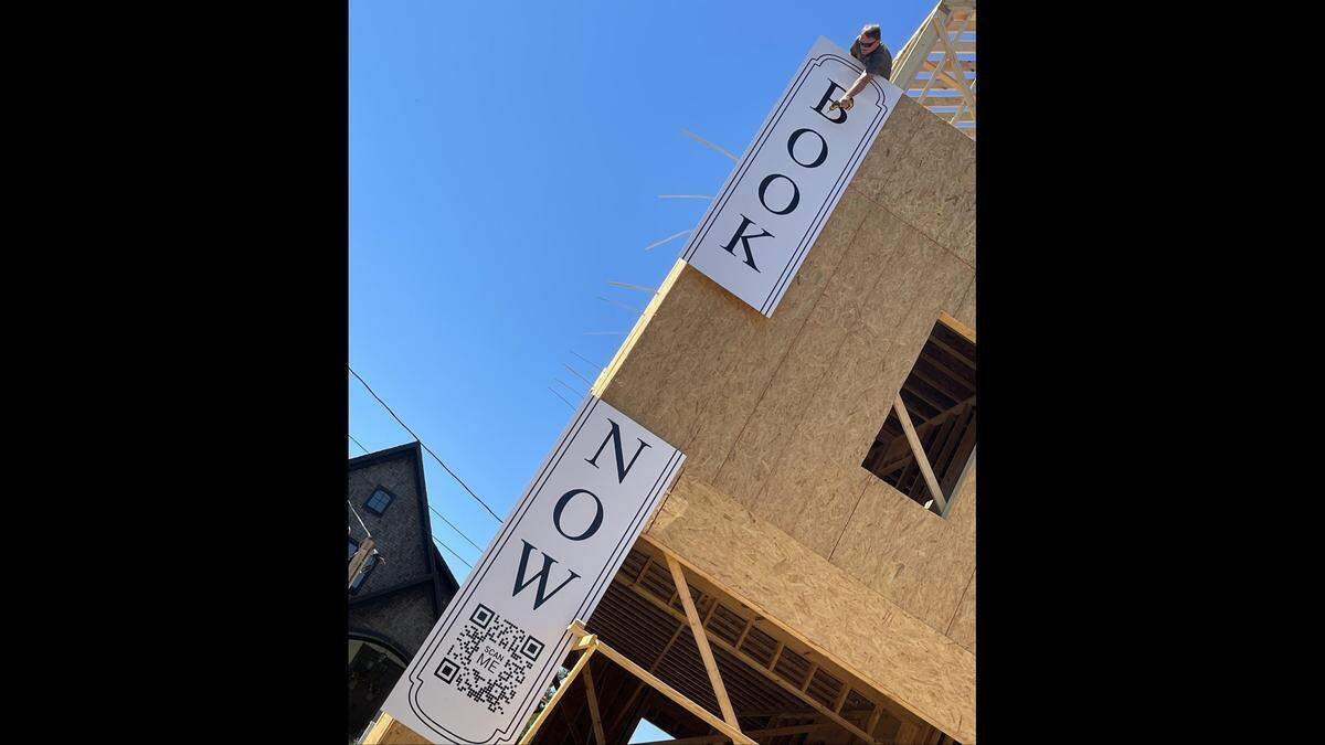 A sign goes up on The Pullman House in downtown Ocean Springs. This group travel destination with four townhouses will open next year, in walking distance to the beach and the downtown fun.