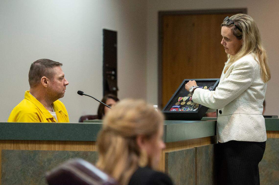 Jacob Blair Scott’s attorney, Tangi Carter, shows Scott his medals earned during his military service during a sentencing hearing in Jackson County Circuit Court in Pascagoula on Thursday, June 2, 2022. When Judge Kathy Jackson handed down Scott’s sentence, she said that his military service was not a defense for sexually abusing his victim.