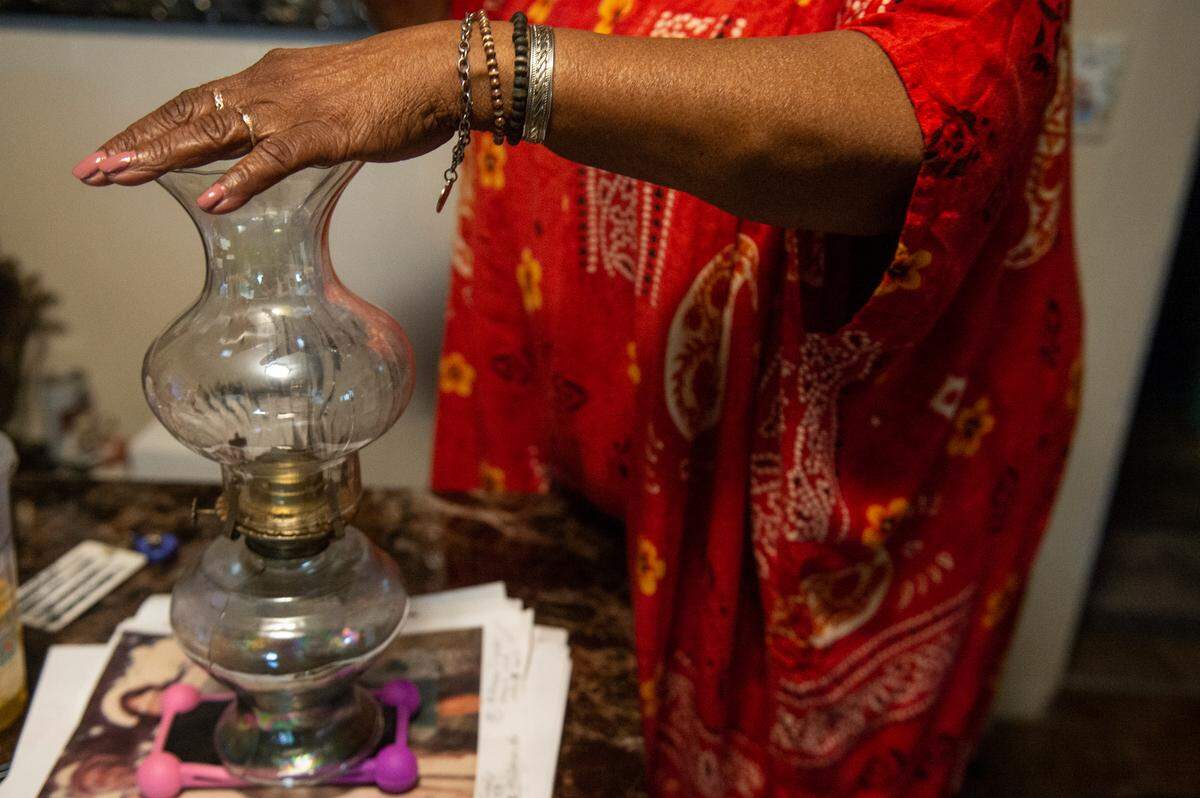 Mary Gipson displays a vintage lantern at the family home on School Street in Ocean Springs on Tuesday, Sept. 26, 2023. Gipson’s father built the house and owned other property in the area.