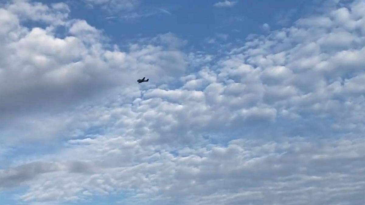 A small airplane circles over Tupelo, Miss., on Saturday, Sept. 3, 2022. Police say the pilot of the small airplane is threatening to crash the aircraft into a Walmart store. The Tupelo Police Department said that the Walmart and a nearby convenience store had been evacuated. (Rachel McWilliams via AP)