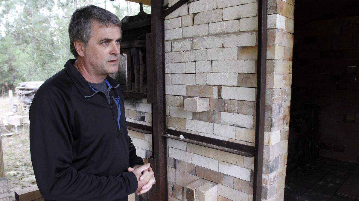 TIM ISBELL/SUN HERALDBrian Nettles stands next to a pottery kiln he built with his apprentice, Joe Geil.