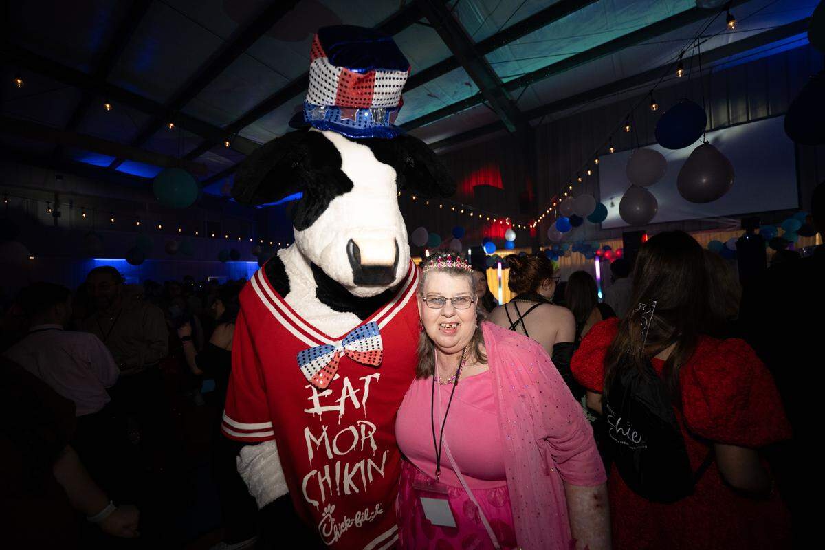 Stormy Madere poses with the Chick-fil-A cow during Night to Shine at Woolmarket Baptist Church on Friday, Feb. 13, 2026.