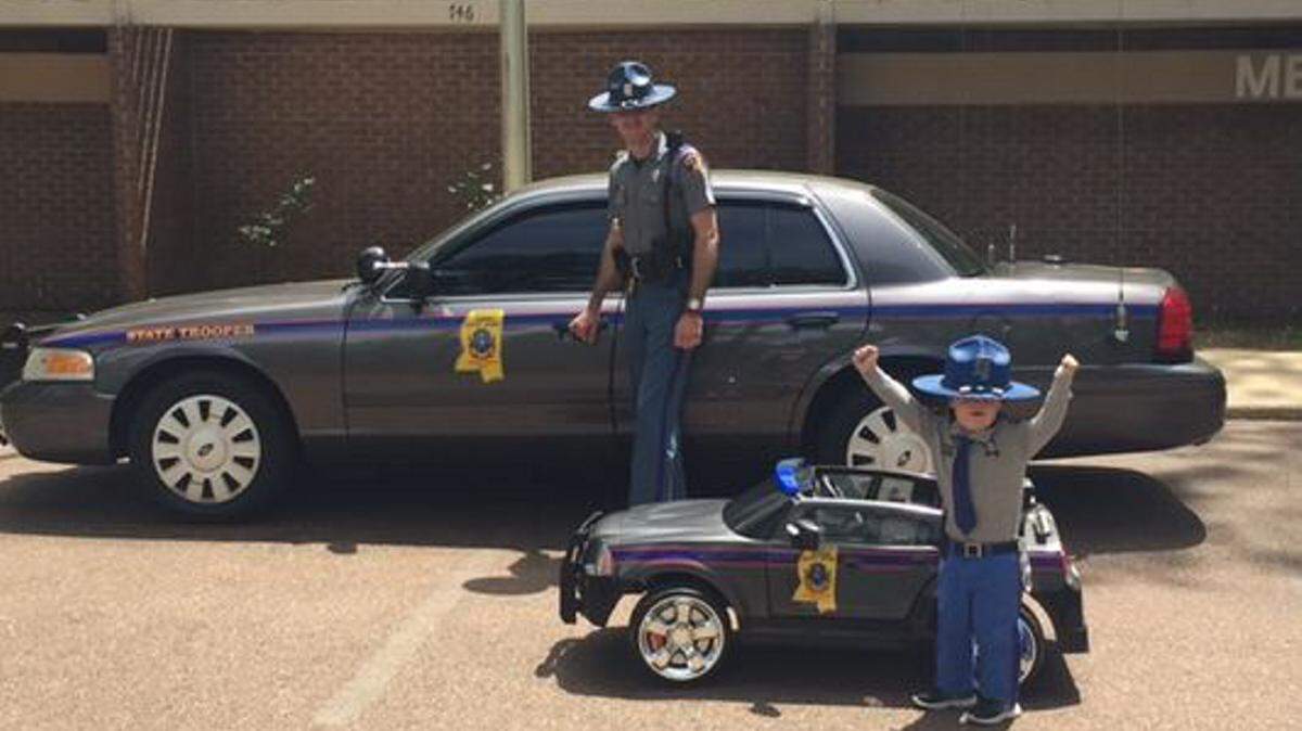 PHOTO COURTESY CLARION-LEDGER/KRISTEN DeDEAUX 
 Trooper Adam DeDeaux and his son Kannon, 2, in a uniform and MHP car Adam designed himself.