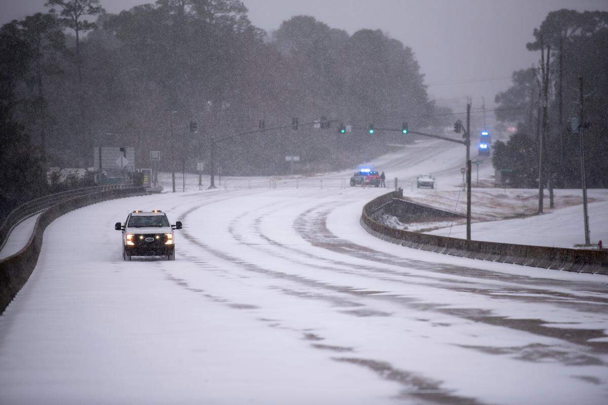An MDOT vehicle drives through the snow along the Fort Bayou Bridge during a winter storm on the Mississippi Coast on Tuesday, Jan. 21, 2025.