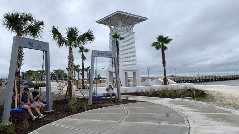 Swings and palm trees welcome people to the beach in this South MS community