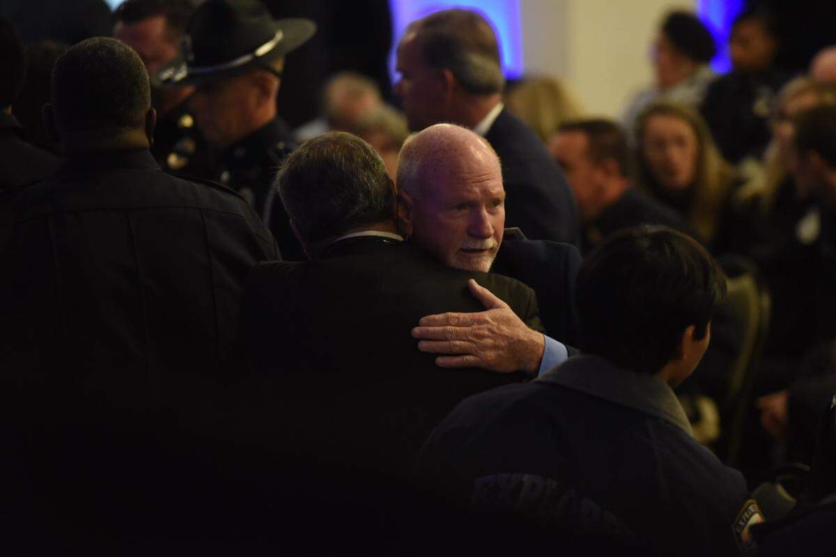 Bay St. Louis Mayor Mike Favre embraces someone at the joint funeral service for fallen police officers Steven Robin and Branden Estorffe on Dec. 21, 2022.