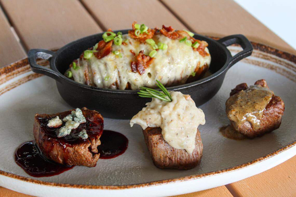 The filet trio at Catch 110 consists of three filet medallions one served au poivre, one topped with blackberry balsamic reduction and gorgonzola, and one topped with lobster mornay sauce.