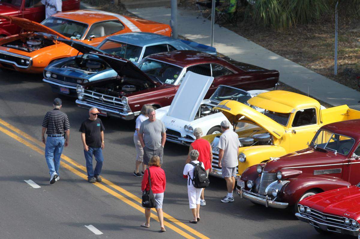 Spectators look at cars parked on Caillavet Street during the Cruisin’ The Coast salute to the military event at MGM Park in Biloxi on Tuesday Oct. 6, 2015.