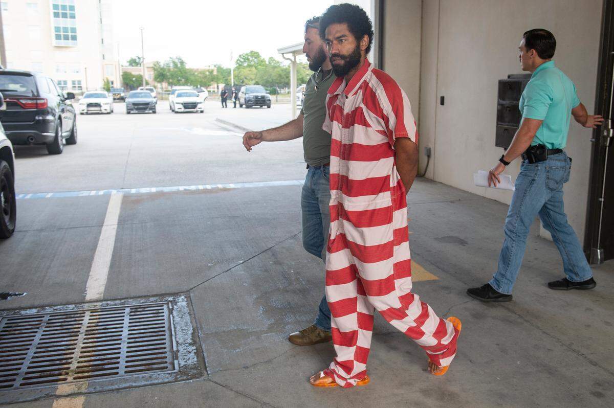 Denilson Marcus Ellison, 27, of Gulfport, is escorted out of the Gulfport Police Department to a waiting vehicle after interviewing with detectives on Friday, April 26, 2024. Ellison is charged with capital murder in the death of his four month old child.